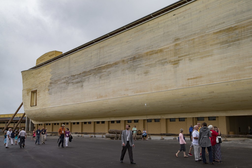 Visitors roam the Ark Encounter theme park as a replica of Noah's Ark stands in the background during a media preview day, Tuesday, July 5, 2016, in Williamstown, Ky. The long-awaited theme park based on the story of a man who got a warning from God about a worldwide flood will debut in central Kentucky this Thursday. The Christian group behind the 510 foot-long wooden ark says it will demonstrate that the stories of the Bible are true. Its construction has rankled opponents who say the attraction will be detrimental to science education. (AP Photo/John Minchillo)
