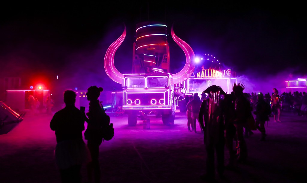In this Tuesday, Aug. 30, 2016 photo, attendees walk by art cars during Burning Man at the Black Rock Desert near Gerlach, Nev. (Chase Stevens/Las Vegas Review-Journal via AP)